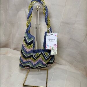 This is a "Made in India" beaded bag with a twisted handle and a chevron pattern